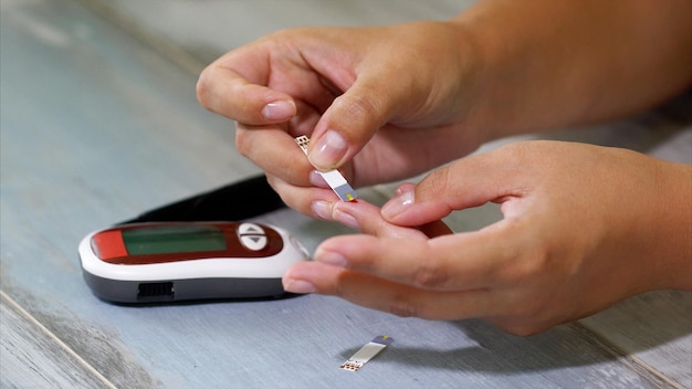 Diabetes Blood glucose meter Adult man measuring sugar level in blood at the table