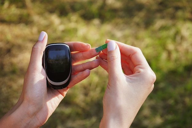 Diabetes concept of glucometer in the hands of a woman for sugar control