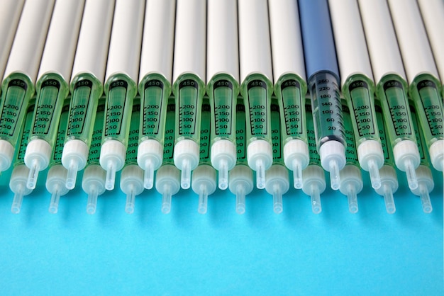 Diabetic insulin pens lined up on a blue background