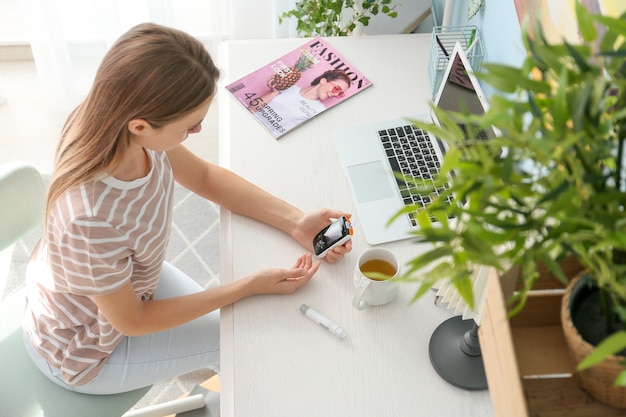 Diabetic woman checking blood sugar level at home