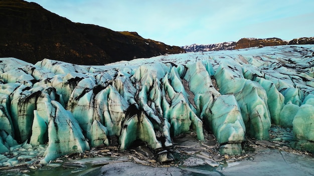 Diamond vatnajokull glacier mass in nordic country surrounded by frozen lake and snowy mountains. Huge icebergs cap creating fantastic scandinavian landscape, covered frost. Slow motion.