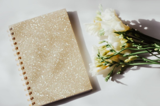 Diary notebook on the background of flowers and wooden figured boards