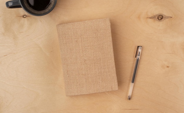 A diary with a pen on a light wooden background Workplace concept Flat lay top view