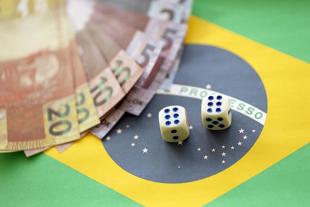 Dice cubes with brazilian money bills on flag of Brasil Republic Concept of luck and gambling in Brasil