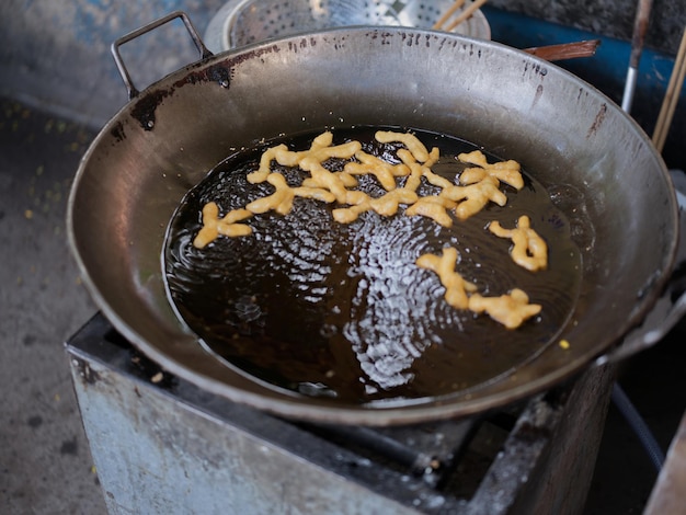 Die cut of Deep fried Chinese Doughnut in an big oil pan