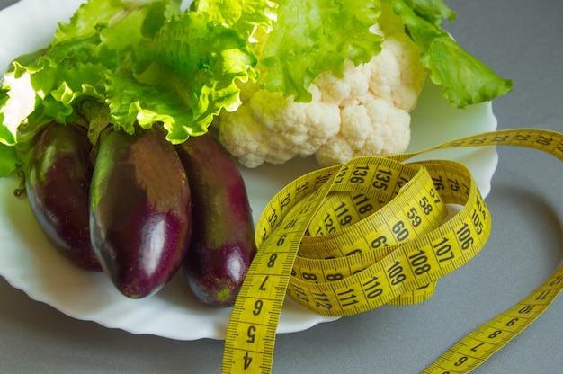 Diet concept healthy eating lettuce cauliflower eggplant measuring tape vegetables