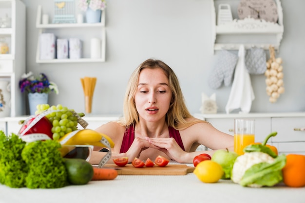 Diet concept with sporty woman in kitchen