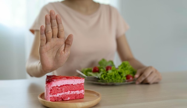 Diet concept Women refuse cake and eat salad for good health