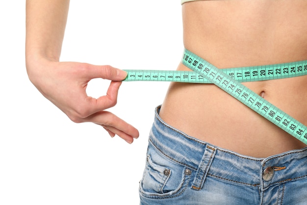 Diet concept. Young woman with measuring tape on white