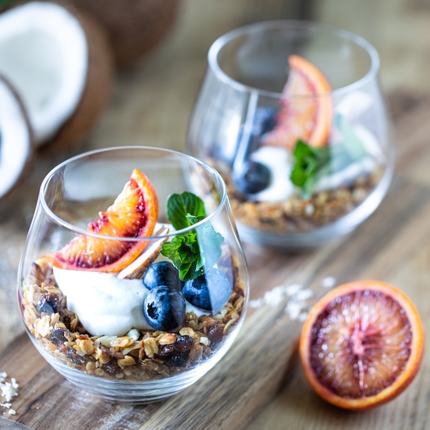 Diet dessert with yogurt, granola and fresh blueberries, red orange, horizontal. Ingredients for a healthy breakfast. Square