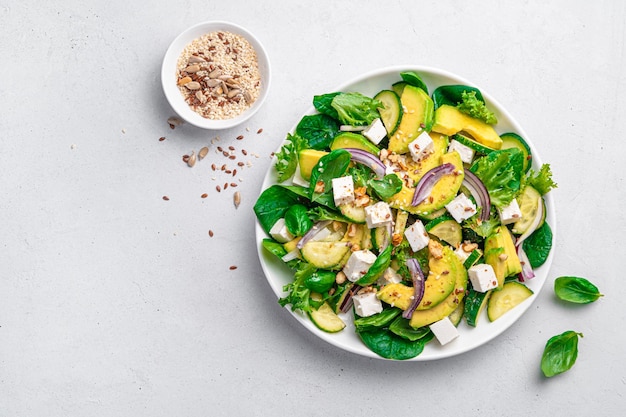 Diet salad with avocado cucumber feta and fresh herbs Top view Healthy food