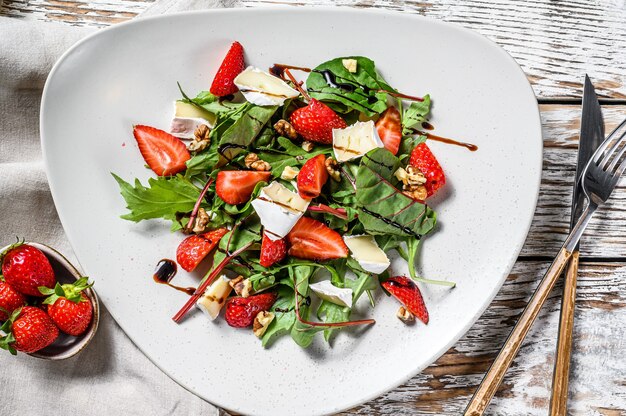 Diet salad with brie cheese, strawberries, nuts, chard and arugula