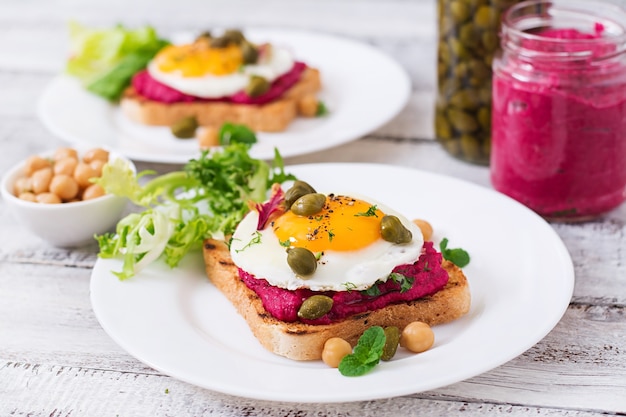 Diet sandwiches with beet root hummus, capers and egg