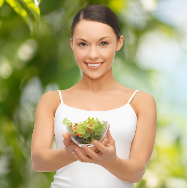 diet and sport concept - healthy woman holding bowl with salad