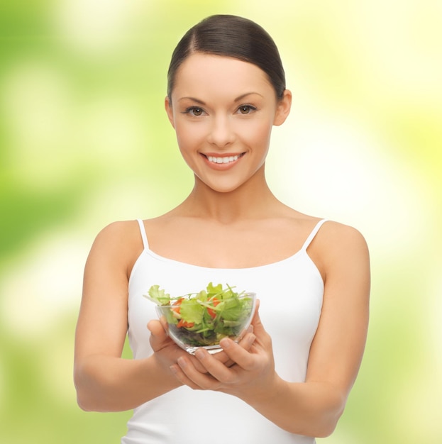 diet and sport concept - healthy woman holding bowl with salad