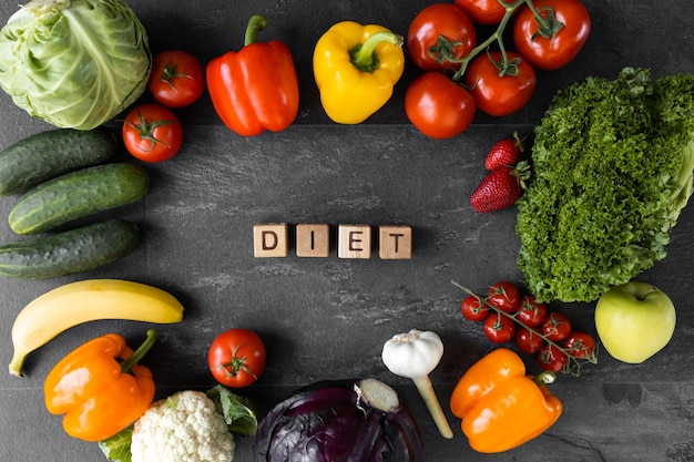 Diet text near healthy food on dark wooden background top view