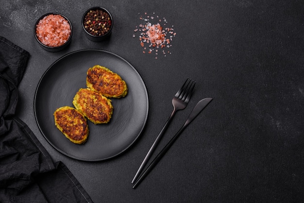 Diet vegetable cutlet from zucchini carrot herbs on a black plate