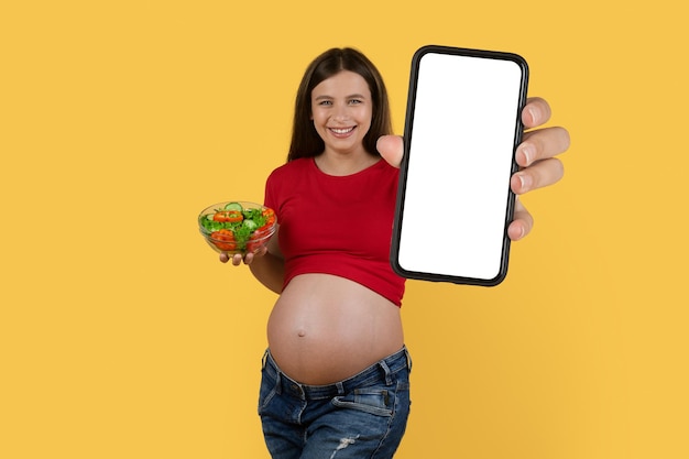 Dieting App Pregnant Woman Holding Blank Smartphone And Bowl With Vegetable Salad