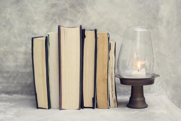 Different books and a candle on a table