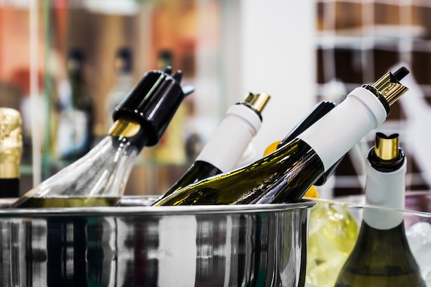 Different bottles of wine and champagne in an ice bucket at a tasting