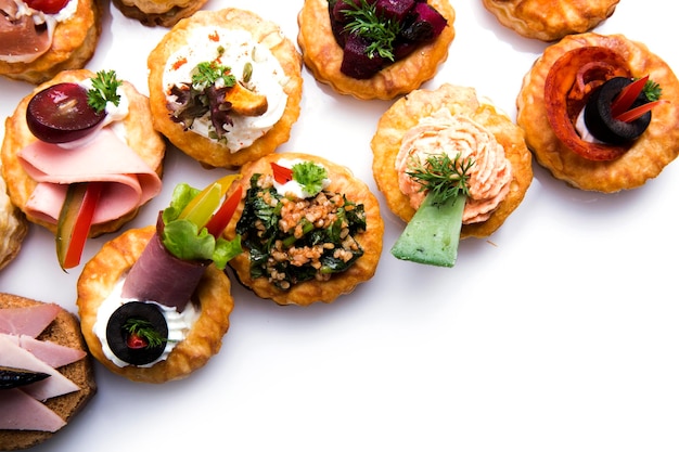 Different canapes with smoked salmon, cucumber cherry tomatoes and mozzarella served on a table