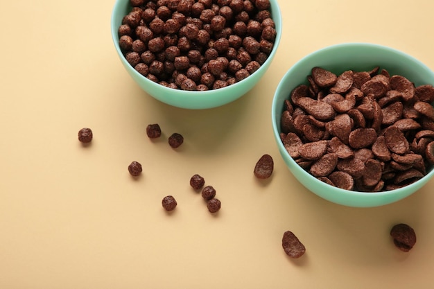 Different chocolate cereal corn in mint bowl on beige background