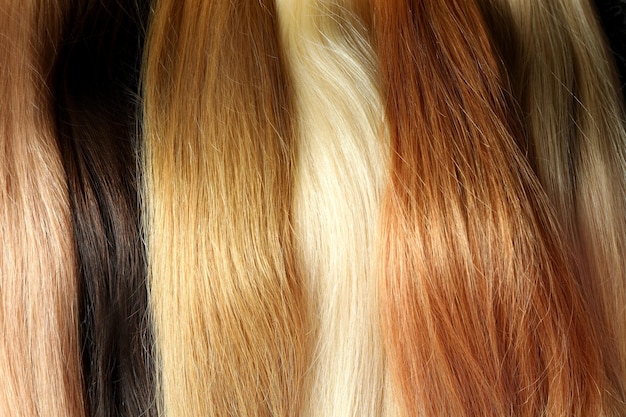 Different color female hair on whole background, close up