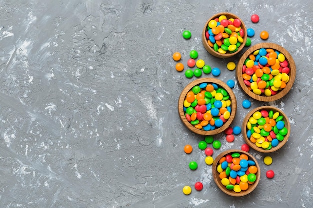 different colored round candy in bowl and jars Top view of large variety sweets and candies with copy space