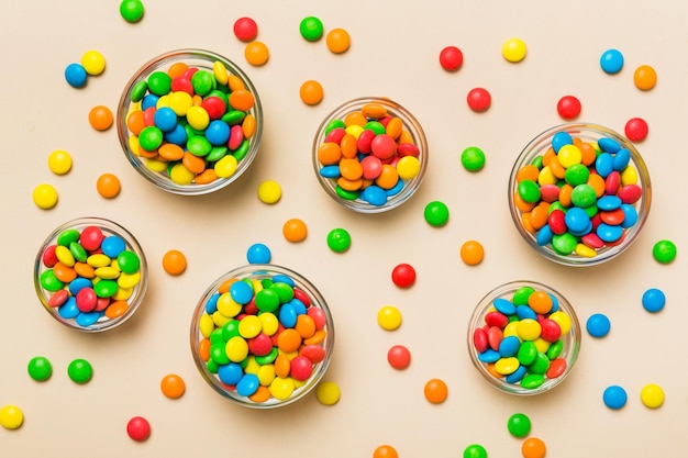 different colored round candy in bowl and jars Top view of large variety sweets and candies with copy space