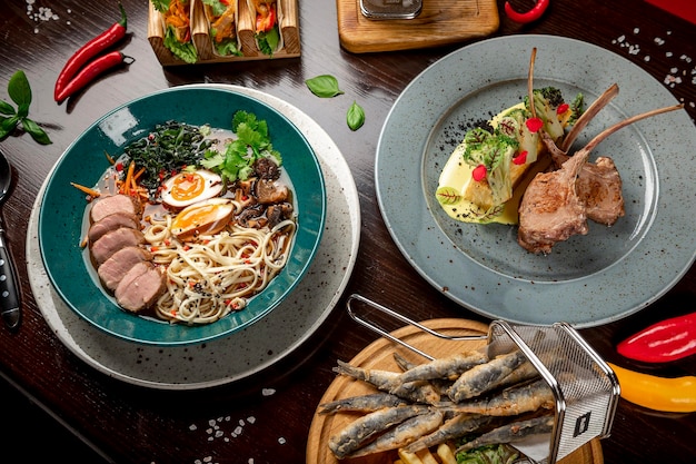 Different colorful meals on dark wooden table in the restaurant