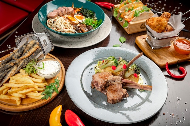 Different colorful meals on dark wooden table in the restaurant