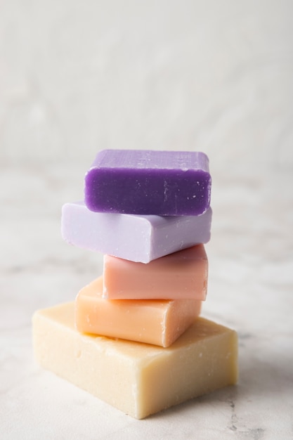 Different colorful soaps on marble background