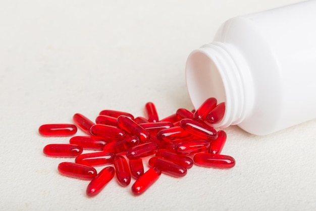 Different drugs and health supplement pills poured from a medicine bottle health care and medical top view on colored background