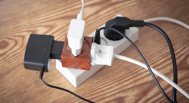 Different electrical plugs and chargers connected extension block.