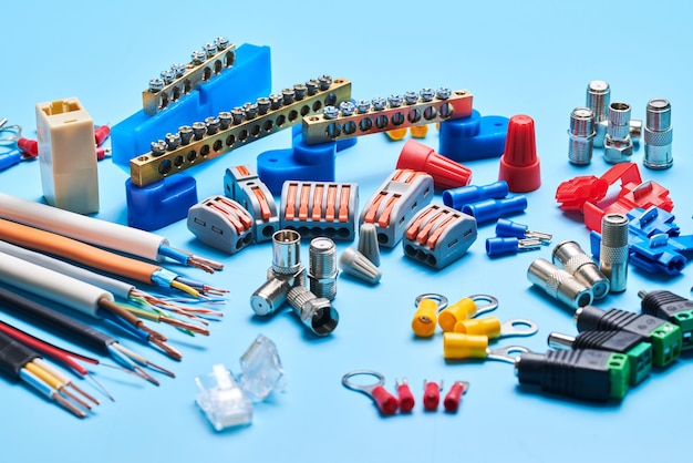 Different electrical tools isolated on blue background electrician equipment wires terminals connectors fuses switches