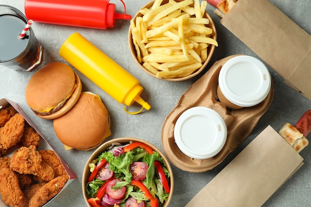 Different fast food on gray textured table