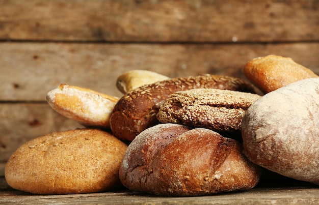 Different fresh bread on old wooden table