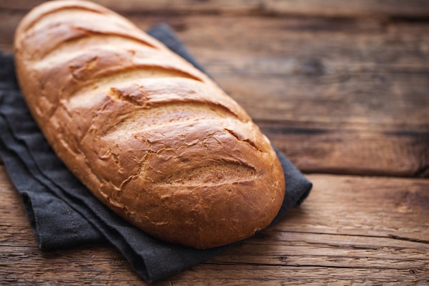 Different fresh bread, on old wooden table.