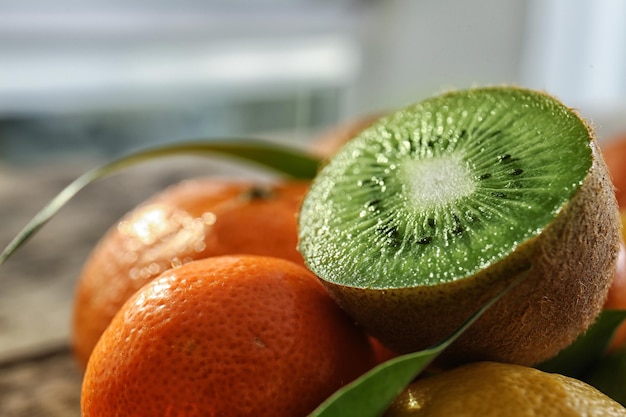 Different fresh citrus fruits with half of kiwi on top closeup