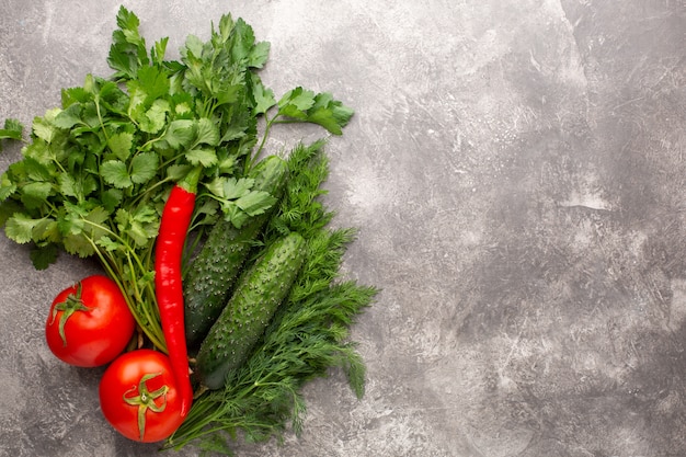 Different fresh greens on a gray concrete surface