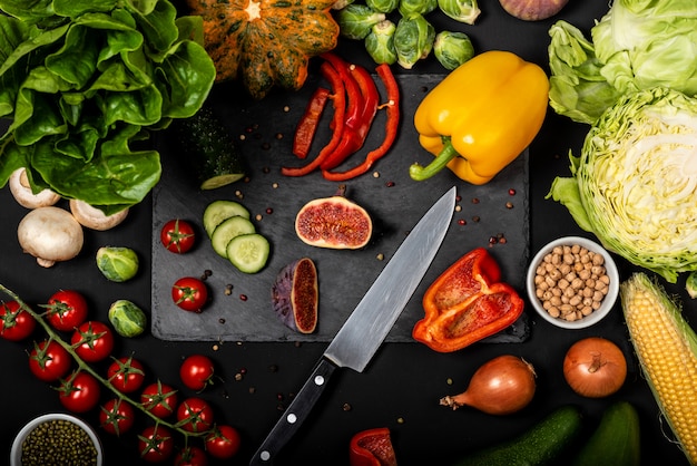 Different fresh vegetables on a black background. Healthy vegetarian food. Top view.