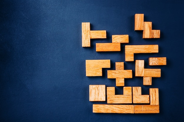 Different geometric shapes wooden blocks arrange in solid figure on a dark background