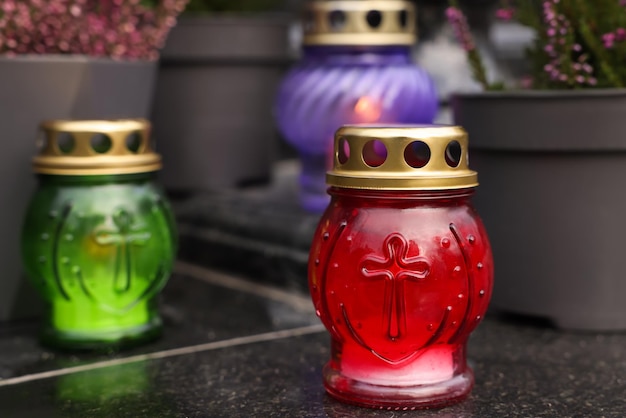 Different grave lanterns on granite surface at cemetery