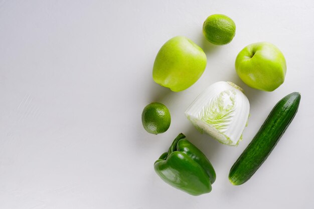 Different green vegetables and fruits on a white background. Healthy food concept. Top view. Copy space