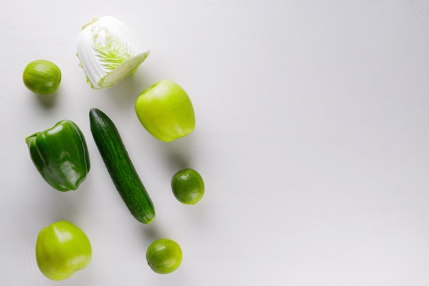 Different green vegetables and fruits on a white background. Healthy food concept. Top view. Copy space