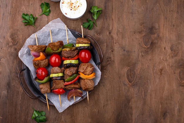 Different grilled kebabs with meat, mushrooms, sausages and vegetable on skewers