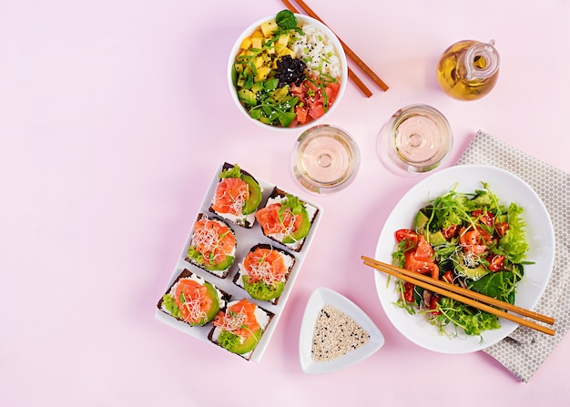 Different healthy salads and salmon sandwiches