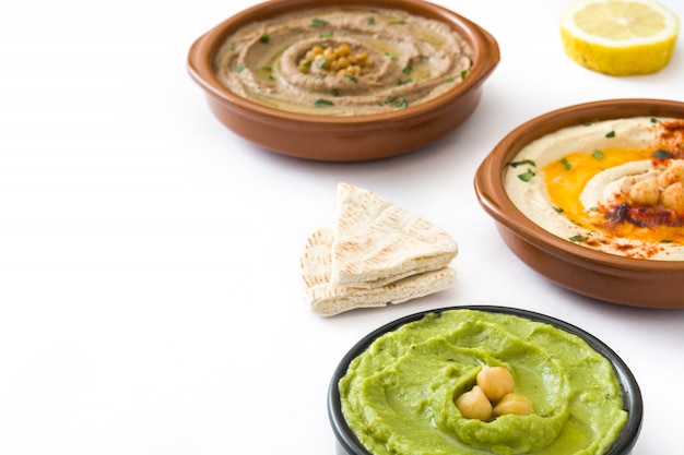 Different hummus bowls Chickpea hummus, avocado hummus and lentils hummus isolated on white