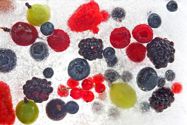 Different juicy berries frozen in ice