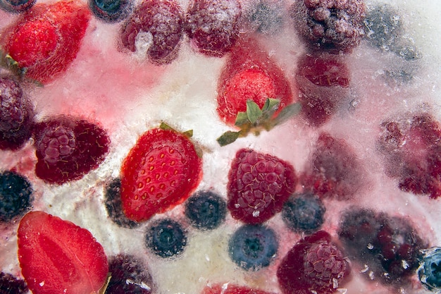 Different juicy berries frozen in ice